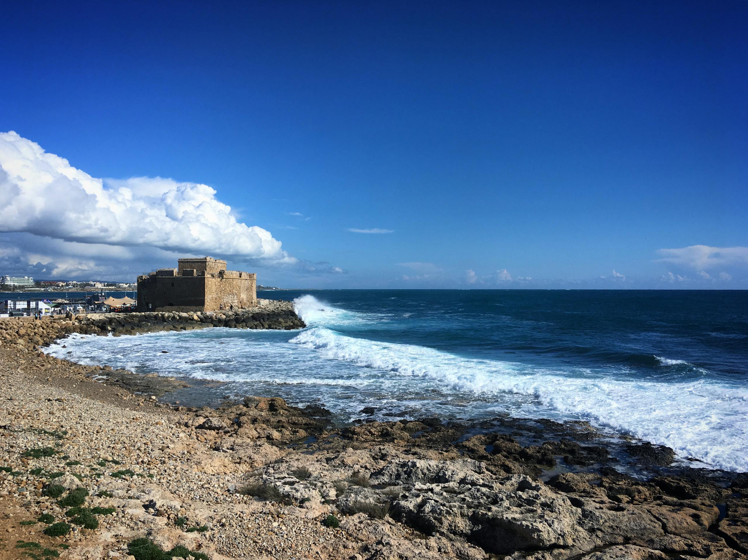 Explore the historic Paphos Castle overlooking the vibrant seascape and rocky shoreline of Cyprus.